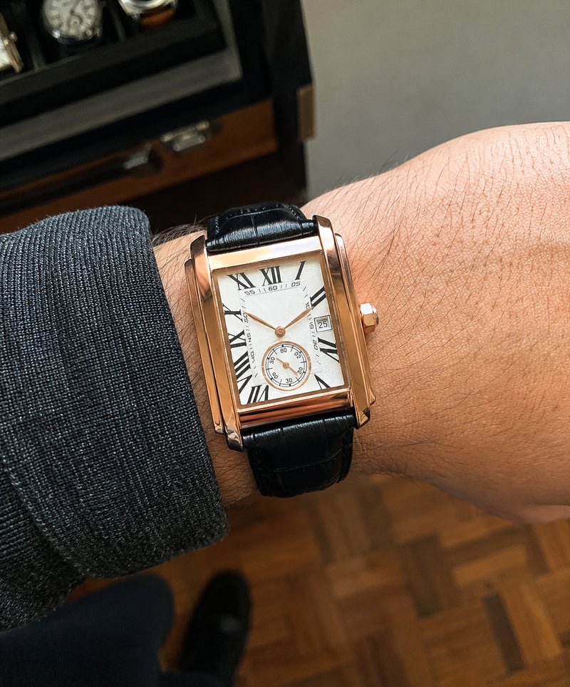 The Founder rose-gold tank watch on the wrist, white dial